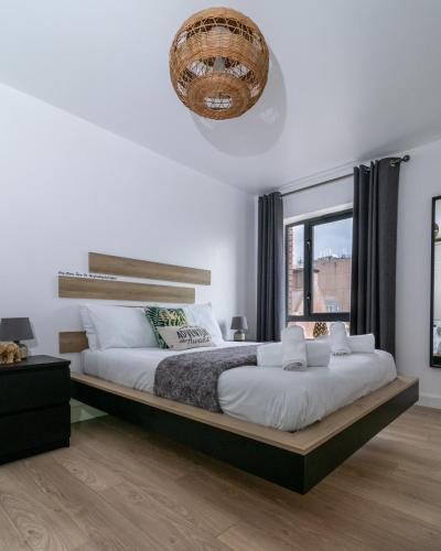 a bedroom with a large bed and a large window at Jucuzzi bath. Japanese toilet. Belfast City Centre. in Belfast