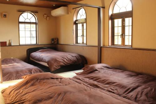 two beds in a room with three windows at Fuefuki - House - Vacation STAY 10281 in Fuefuki