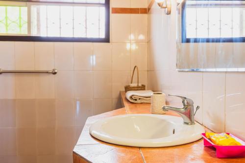a bathroom with a sink and a window at Aparthotel Jardin Tropical in Bujumbura