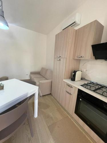 a small kitchen with a stove and a couch at U Curtigliu apartment in Realmonte