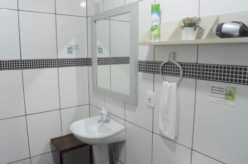 a white bathroom with a sink and a mirror at Hospedagem Da Laranjeira Gramado in Gramado