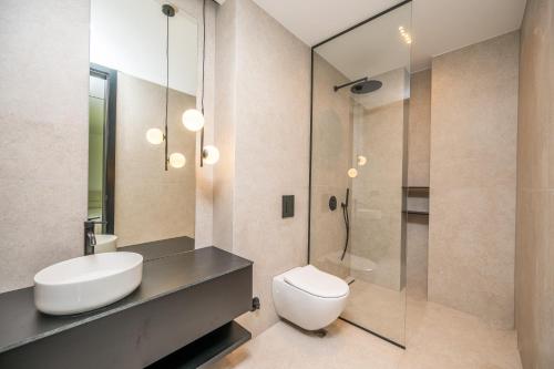a bathroom with a toilet and a sink and a shower at The Villa O in Sarajevo