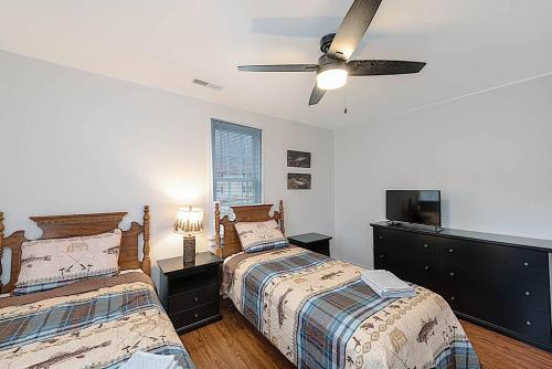une chambre avec deux lits et un ventilateur de plafond dans l'établissement Jackson River Estate Cozy Cottage on the River, à Covington