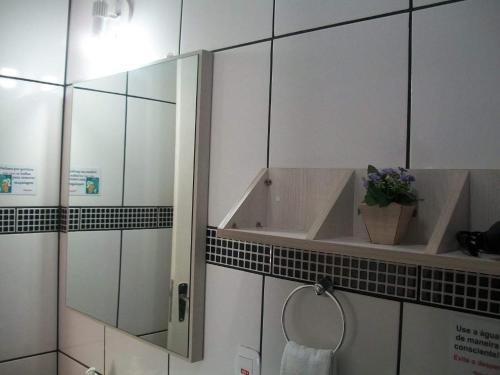 a bathroom with a shower with a sink and a mirror at Hospedagem Da Laranjeira Gramado in Gramado