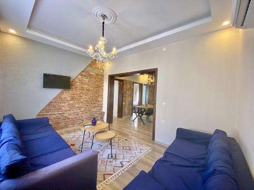 un soggiorno con divano blu e muro di mattoni di Kesik Apart a Antalya (Adalia)