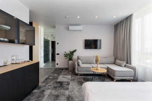 ein Hotelzimmer mit einem Bett und einem Sofa in der Unterkunft Be The One Hotel in Kiew