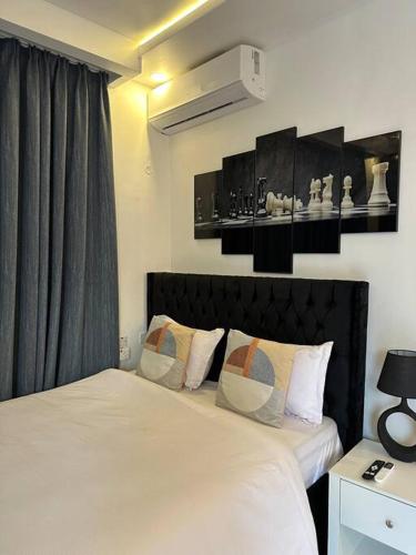 sypialnia z łóżkiem z białą pościelą i poduszkami w obiekcie MCM _Haven w mieście Dar es Salaam