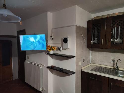 a kitchen with a flat screen tv on the wall at Casa Scanno centro storico in Scanno