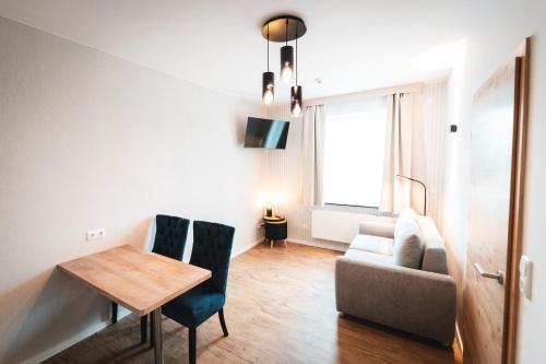 een woonkamer met een tafel en een bank bij Hotel Elbe-Herz-Appartement in Wittenberge