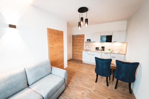 een woonkamer met een bank en een tafel en stoelen bij Hotel Elbe-Herz-Appartement in Wittenberge