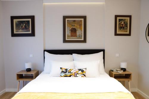 1 dormitorio con 1 cama blanca y 2 mesas en Treetop Apartments en Vršac