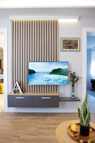 a living room with a flat screen tv on a entertainment center at Treetop Apartments in Vršac