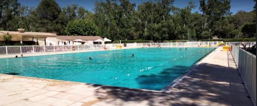 une grande piscine avec des gens dans l'eau dans l'établissement LES BALCONS, à Six-Fours-les-Plages
