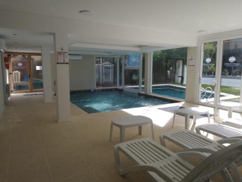 una piscina en una casa con sillas y una piscina en Alley Pampa en Mar de las Pampas