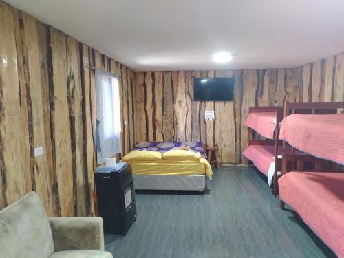 a room with two beds and a television in it at Cabaña cunco 6 personas in Cunco