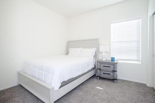 a white bedroom with a white bed and a window at MM house in Marana