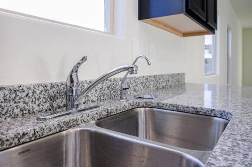 a stainless steel sink in a kitchen with granite counter tops at MM house in Marana