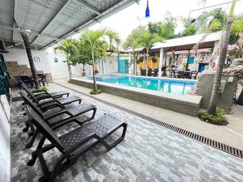 a row of chairs sitting next to a swimming pool at Casa Halley #2 con vista al mar , Playas in Data de Posorja