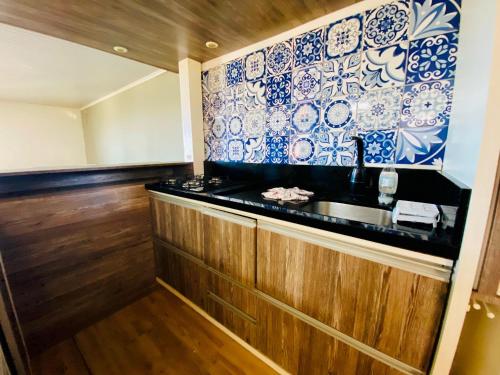 a kitchen with blue and white plates on the wall at Refugio Por do Sol - 09 Pessoas - WiFi- Ar Condicionado in Gramado