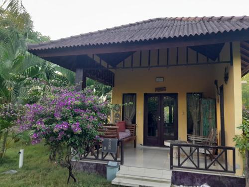 a small house with a porch and flowers at Adinda bungalaow in Gili Islands