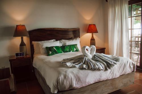 a bedroom with a bed with two swans on it at Hotel Playa Cambutal in Cambutal