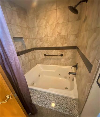 a bath tub in a bathroom with a shower at The Tahoe Beach & Ski Club Owners Association in South Lake Tahoe