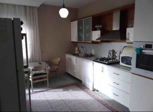 a kitchen with white cabinets and a table in it at Квартира in Antalya