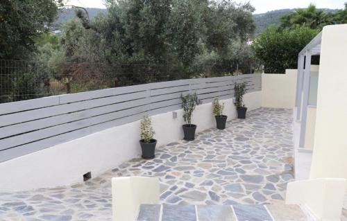 a fence with potted plants on a patio at Fiosal Apartments 2 in Skiathos Town