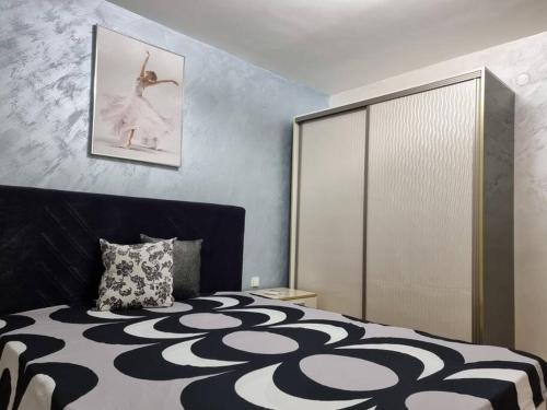 a bedroom with a bed with a black and white comforter at Oazis resort lux vip apartament in Lozenets