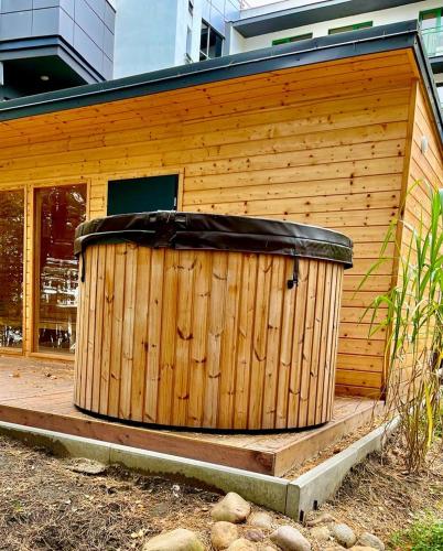 a wooden building with a large wooden tub in front at Apartament nad Zalewem Zegrzyńskim in Serock