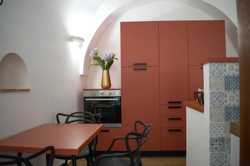 una cucina con armadi arancioni e tavolo con sedie di San Martino [Old Town Apartment - Itri] a Itri