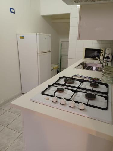 a kitchen with a stove and a white refrigerator at La Casa di Adele AFFITTACAMERE in Porto SantʼElpidio