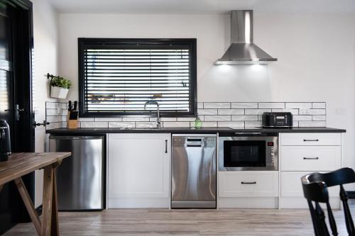 a kitchen with stainless steel appliances and a window at Cricklewood- 2 bedroom enchanting miner's cottage in Daylesford