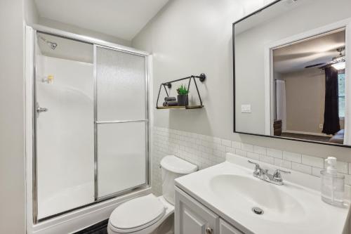 a white bathroom with a shower and a sink at Macon Cottage with Porch - 2 Mi to Downtown! in Macon