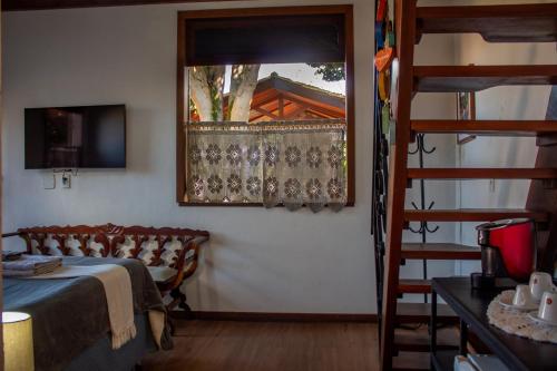 a bedroom with a bed and a staircase with a window at Villa Santo Antonio - Mucugê in Mucugê
