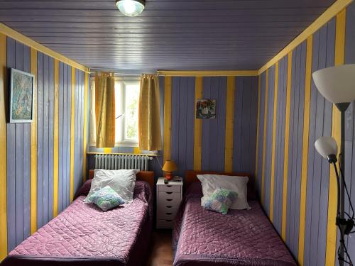 2 camas en una habitación pequeña con paredes a rayas en Chambres d’hôtes chez Colombet, en Tardets-Sorholus
