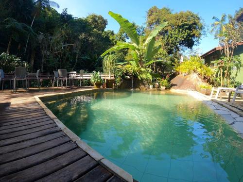 a large swimming pool with a wooden walkway around it at Pousada do Riacho Trindade in Trindade