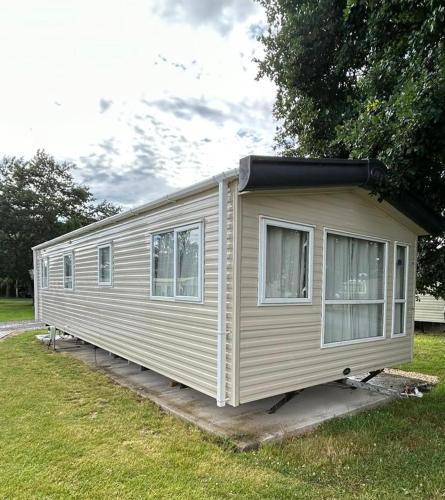 a mobile home is parked in the grass at Ralph’s Retreat in Cottam