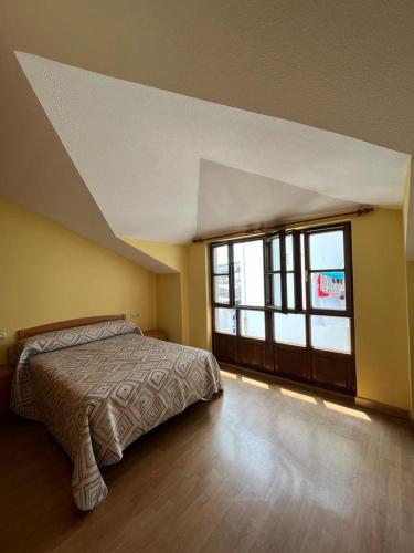 1 dormitorio con cama y ventana grande en Duplex Luarca, en Luarca