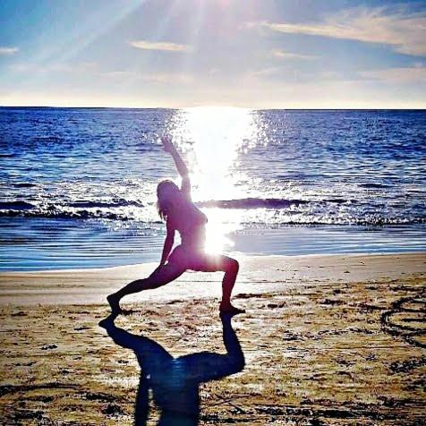 a woman doing a yoga pose on the beach at Villa Star of the Sea in Barra de Navidad