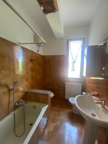 een badkamer met een bad, een wastafel en een toilet bij Casa Rosati - Baia Flaminia in Pesaro