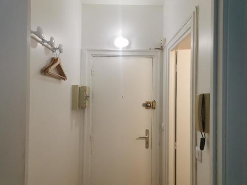 La salle de bains est pourvue d'une porte et d'une lumière sur le mur. dans l'établissement Studio Blue Nest l Cosy I Wifi Fibre I, à Grenoble