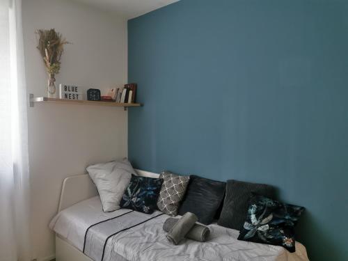 - un canapé dans une chambre dotée d'un mur bleu dans l'établissement Studio Blue Nest l Cosy I Wifi Fibre I, à Grenoble