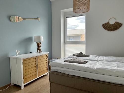 ein Schlafzimmer mit einem Bett, einer Kommode und einem Fenster in der Unterkunft COAST HOUSE Seaside Loft in Bremerhaven