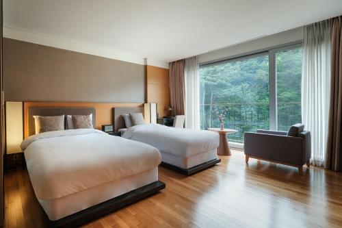 una camera d'albergo con due letti e una finestra di The Suites Hotel Namwon a Namwon