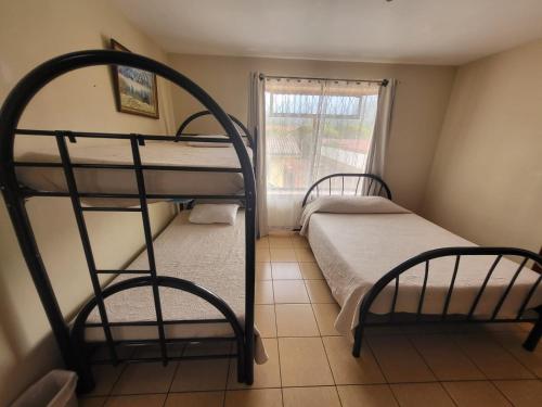 two bunk beds in a room with a window at Hotel Valle Verde in San Joaquín