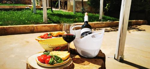 uma mesa com uma garrafa de vinho e um copo em TORRE VECCHIA RELAIS em Ugento