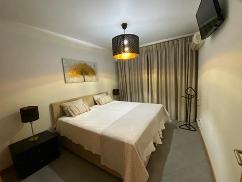 a bedroom with a bed and a television in it at Atlantic Sun & Love Apartment in Portimão