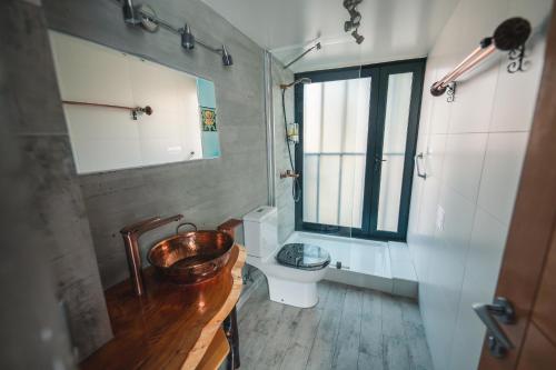 a bathroom with a wooden sink and a toilet at AYCA La Flora Hotel Boutique in Valparaíso
