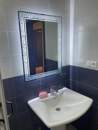 a bathroom with a white sink and a mirror at Appartement De Luxe A Wilaya De Tetouan in Tetouan